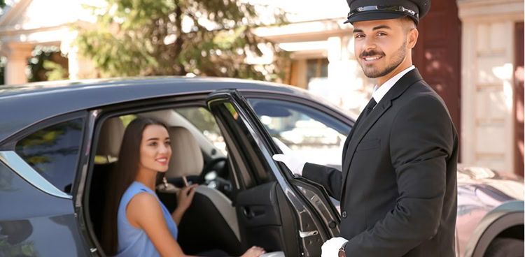 Multilingual chauffeur welcoming guests at a luxury car