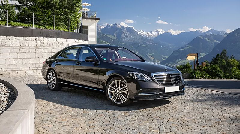 Chauffeur opening a luxury car door for a guest in Lake Como